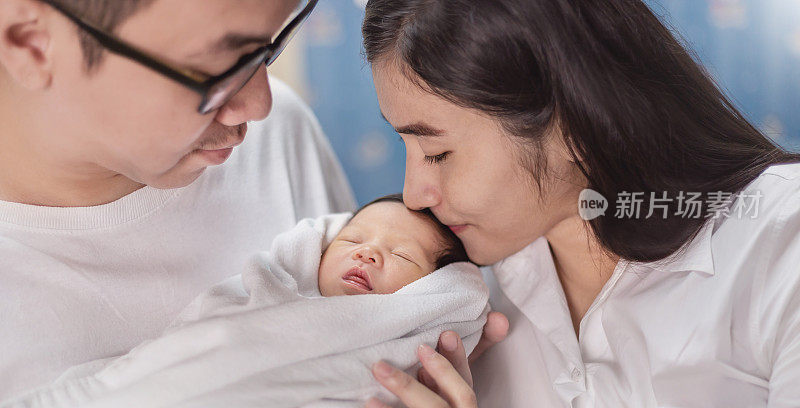 Asian parents mom kiss newborn baby, Closeup portrait of asian young couple father mother holding kissing new born baby in hospital bed Happy asia family love newborn nursery motherâs day holiday concept
